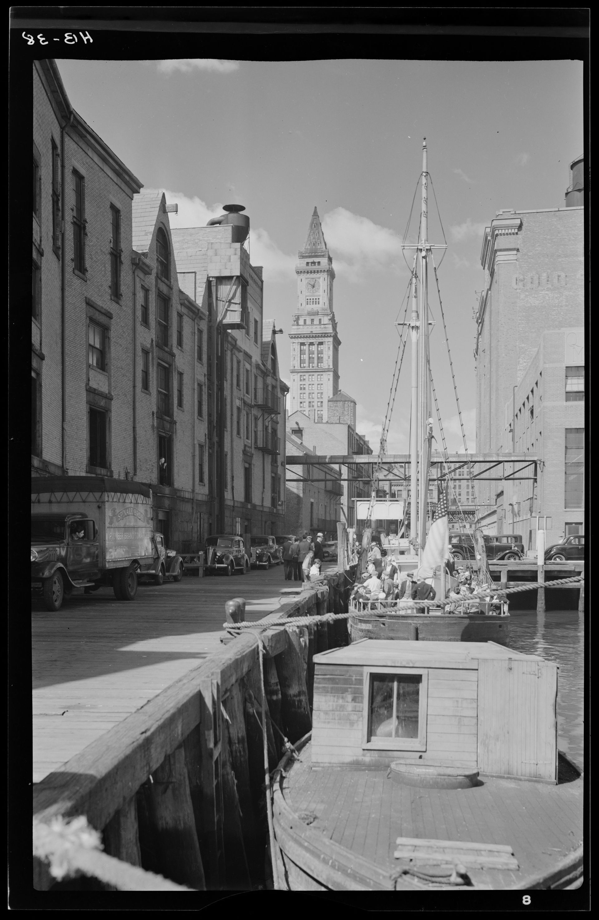 Photo from between 1928 and 1938 showing the Custom House Tower from the end of a busy long wharf
